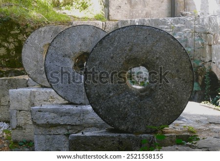 Ancient stone wheels in old mill by in rural countryside
