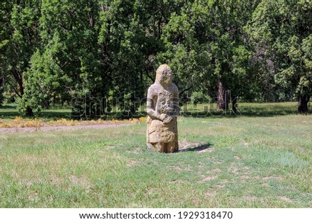 Ancient stone woman on a green lawn in biosphere reserve Askania-Nova, Ukraine