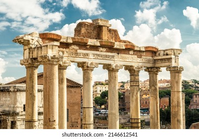 Ancient Temple of Saturn in Roman Forum, Rome, Italy, Europe. It is landmark of Rome. Old columns rise over Forum ruins and city buildings in Roma center. Concept of travel in Rome, history of Italy. - Shutterstock ID 2146612541