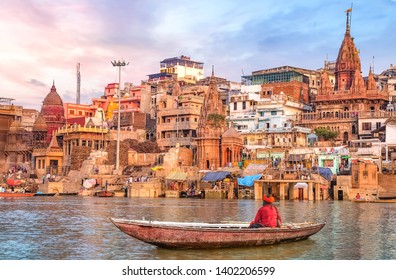 Ancient Varanasi byarkitektur ved solnedgang med udsigt over sadhu baba nyder en bådtur på floden Ganges.
