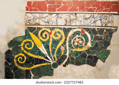 Ancient wall adorned with a vibrant handmade freeform-tiles mosaic, showcasing a floral pattern.