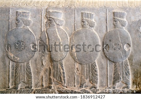 Ancient wall with bas-relief with assyrian warriors with with spears and shields, Persepolis, Iran. UNESCO world heritage site