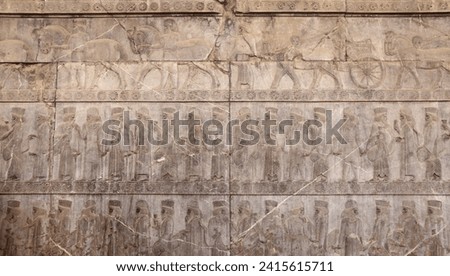 Ancient wall with bas-relief with assyrian warriors with spears,  horses, chariots, Persepolis, Iran
