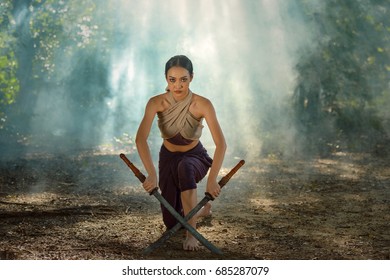 Ancient warrior man of soldier of Bang Rachan District Thailand hold sword fight,Images of dirty middle-aged fighters and swords. Smoke cloud on a black background.Thailand