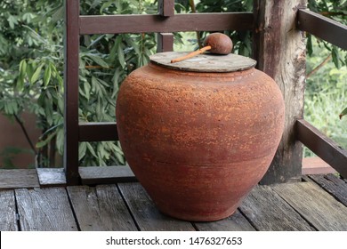 Ancient Water Jar On Wooden Porch