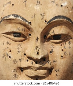 Ancient wooden face showing acupuncture points 