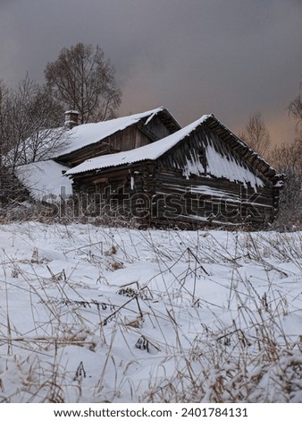 Ancient wooden houses covered with snow on a hillock. After a heavy snowstorm, the field and houses are covered in snow. The weather is in watercolor tones.
