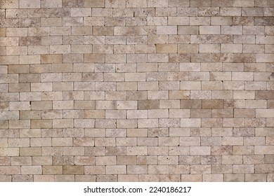 Ancient yellow brick wall background texture with old masonry close up