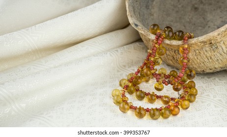 Ancient Yellow Glass Button Necklace Separated By Small Red Trade Beads On A Pot And Thai Silk Background