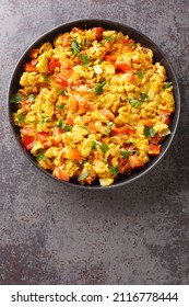 Anda Bhurji is an Indian Style Spicy Scrambled Eggs closeup in the plate on the table. Vertical top view from above
