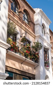 Façade Of Andalusian House In Nerja , Costa Del Sol , Malaga. Flower In Balcony, Andalusian Architecture, Typically White Houses ,with Stone Décor And Flowers In The Balcony. 