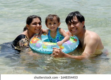 Andaman  Nicobar Islands India- Asia; Sep. 30, 2008 -  Indian Family Parents With Little Cute Girl Enjoying Swimming At Wandoor Beach South Andaman 
