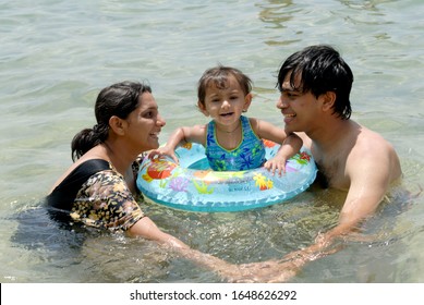 Andaman  Nicobar Islands India- Asia; Sep. 30, 2008 -  Indian Family Parents With Little Cute Girl Enjoying Swimming At Wandoor Beach South Andaman 
