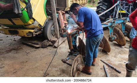 Andoolo, Indonesia - July 2021: The Mechanic Is Welding The Back Of The Plow