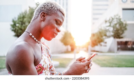 Androgynous Man Using Smartphone On Street