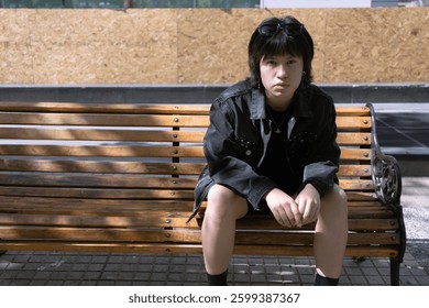 Androgynous Teen in a Thoughtful Moment on a Park Bench