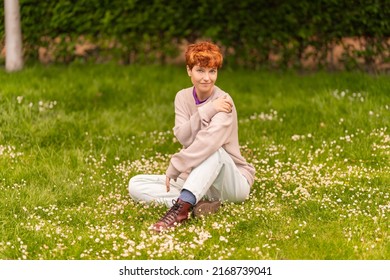 Androgynous Woman Resting On Lawn In Park