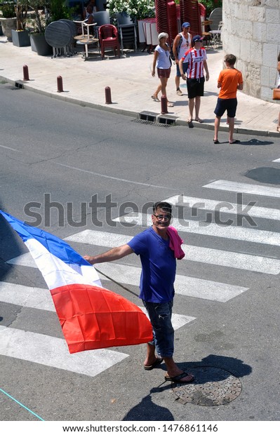 ANDUZE – FRANCE, JULY 23, 2019: Tour de\
France supporters and their French flag in\
Anduze