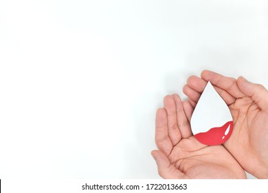 Anemia, and World Blood Donor Day concept. Male hands holding an anemic blood drop cutout in white background. 