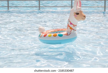 Anenii Noi,Moldova-07.01.2022:llama Inflatable Ring Swimming Balloon Floats On Water Pool.lot Of Childrens Are Playing In The Background,enjoy The Summer Time,heat Warm Weather.cute Llama Shape