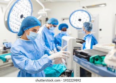 Anesthesiologist Keeping Track Of Vital Functions Of The Body During Cardiac Surgery. Surgeon Looking At Medical Monitor During Surgery. Doctor Checking Monitor For Patient Health Status.