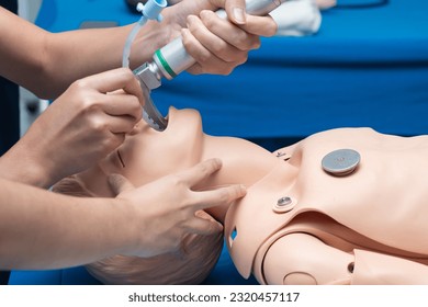 Anesthesiologist performing an orotracheal intubation on a simulation, mannequin dummy during medical training to control of the airway. - Powered by Shutterstock