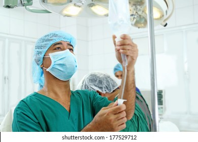Anesthesiologist regulating an iv drip inside the operating room.