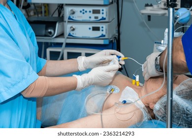 Anesthesiologists administer general anesthesia to a patient on the operating table. Surgery under epidural anesthesia. Doctors administer anesthesia through a system of catheters. - Powered by Shutterstock