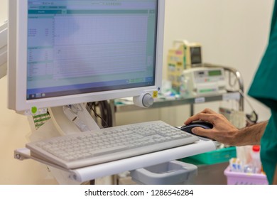 An Anesthetic Machine In Modern Operating Room  With The Hand Of Doctor Working On Computer .Anesthesia Gave To Patient Before Performing Surgery In Hospital. Medical Concept.