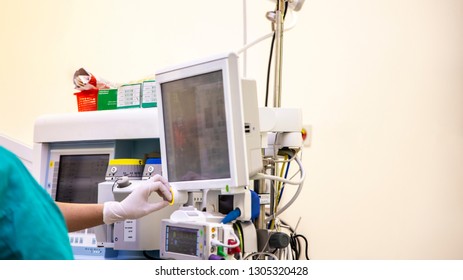 An Anesthetic Machine In Modern Operating Room  With The Hand Of Doctor Working On Computer .Anesthesia Gave To Patient Before Performing Surgery In Hospital. Medical Concept.