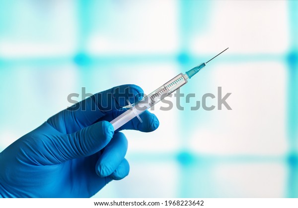anesthetist in cosmetic surgery clinic with a\
syringe to anesthetize a patient before the intervention. Doctor\
preparing dose of vaccine in syringe for the vaccination plan\
against diseases