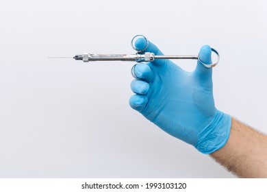 Anesthetist dentist doctor holds in his hand anesthesia syringe prior to dental surgery. Hand in a rubber glove that fits to one side