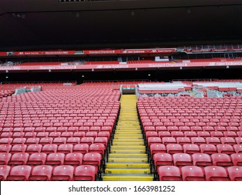 Anfield , Liverpool, England-September24,​ 2019 ​: Anfield Stadium, The Home Ground Of Liverpool Football Club. The Red Empty Plastic Seats In A Stadium With Yellow Walkway.