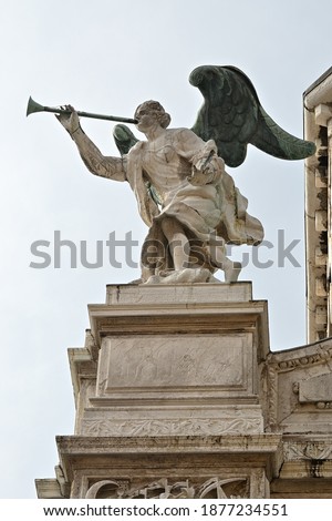 The angel blew his trumpet, antique decorations statue on the facade of a palace in Venice, Italy. Bible plot of the Revelation story about The Seven Angels with the trumpets