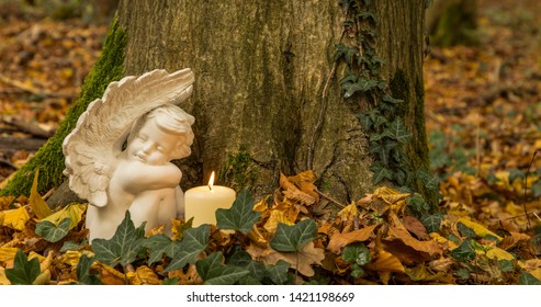 Angel with candle, nature cemetery. Moment of grief at the end of a life. Last farewell. Funeral concept.