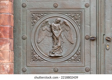 Angel carving on church doors in Berlin, Germany. Detail of the metallic panel on the temple doorway, entrance to the church. - Shutterstock ID 2218802439