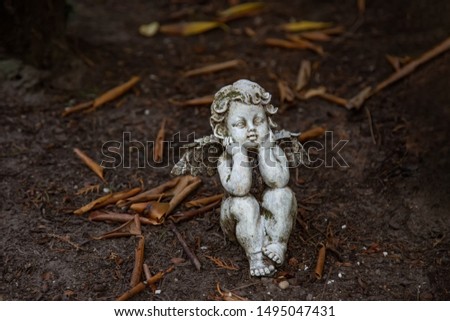 An angel figure sits on the ground
