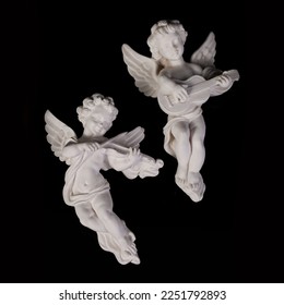 Angel figurine isolated on black background. Cupid with bow and arrow. Antique porcelain cupid figurine close-up