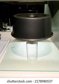 Angel Food Cake In Tube Pan Upside Down On Glass Cooling. Vertical Shot