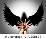 Angel, hand shadow like wings of darkness