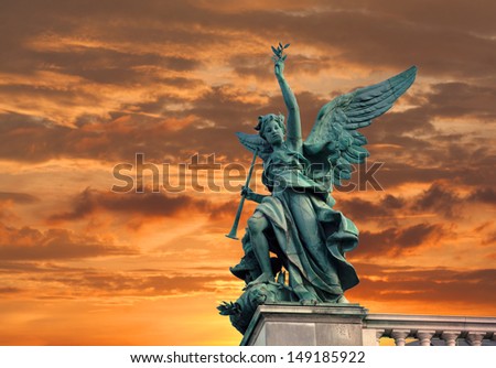 Angel sculpture on sunset background