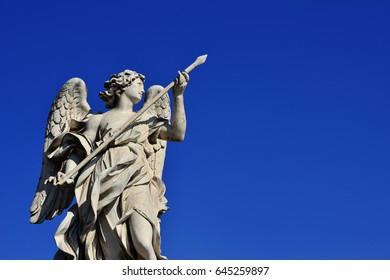 Angel Statue Holding The Holy Lance Of Longinus On Sant'Angelo Bridge In Rome (with Blue Sky And Copy Space)