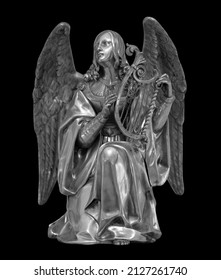 Angel statue isolated on black background with clipping path. White stone sculpture of praying cherub