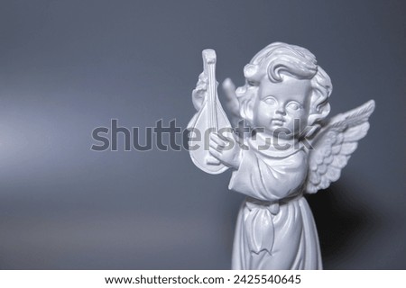 Angel statue isolated on white background. White stone sculpture of praying cherub.