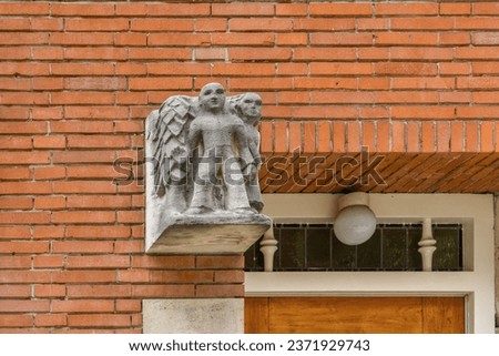 an angel statue on the side of a brick building with a wooden door and window in the photo is taken from above