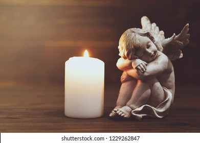 Angel and white burning candle  