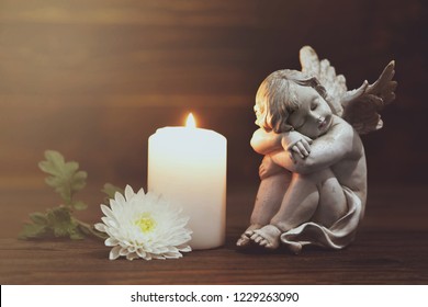 Angel, white flower and burning candle  
