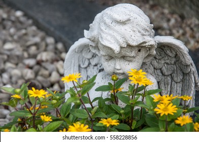 Angel And Yellow Flowers On A Grave