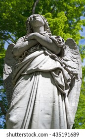 An Angelic Statue In A Cemetery Looking Heavenward.