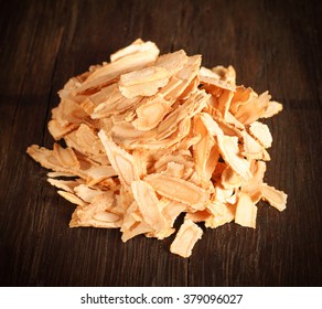 Angelica root slices isolated on a dark brown wooden background